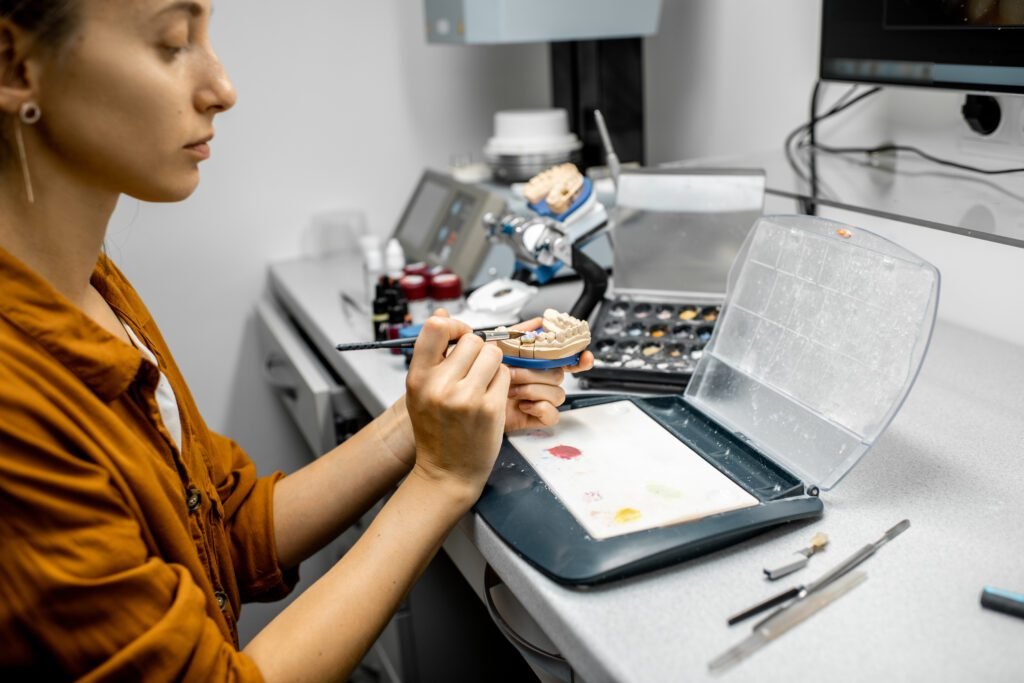 Dental technician coloring dental prosthesis
